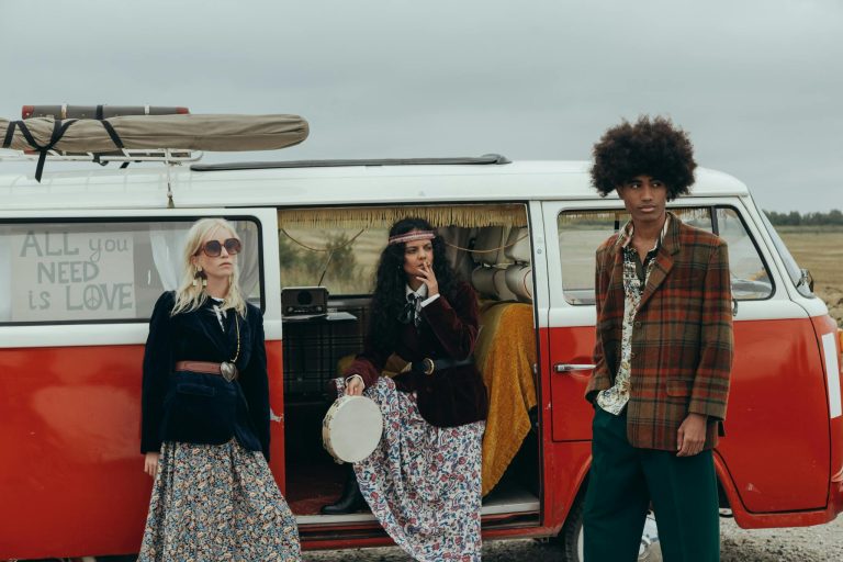 Group of bohemian friends by a vintage campervan enjoying a retro vibe.