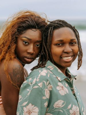 Joyful black lesbian couple enjoying a day at the seaside, exuding warmth and connection.