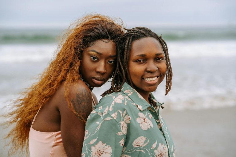 Joyful black lesbian couple enjoying a day at the seaside, exuding warmth and connection.